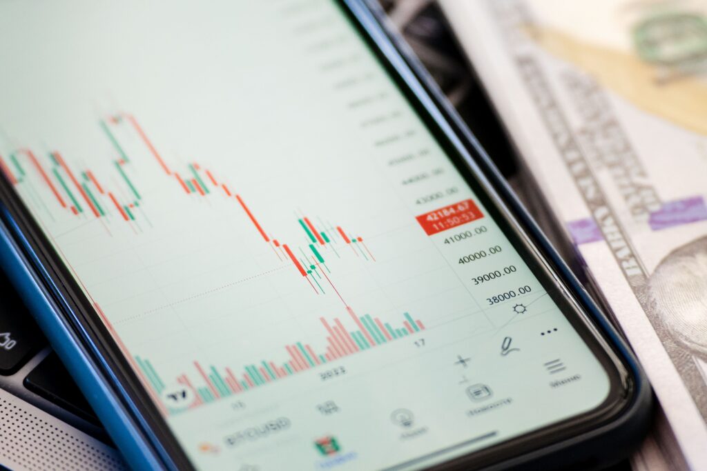 Detailed view of stock market data on a smartphone with US dollars in the background, illustrating trading.
