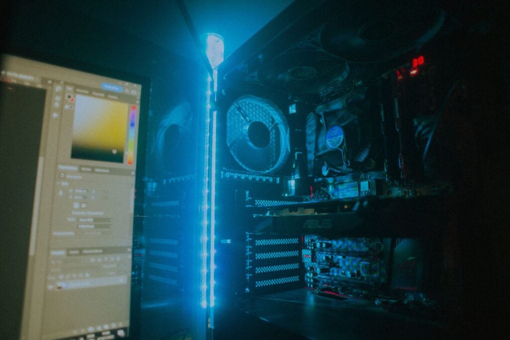 Close-up of an illuminated gaming PC setup showcasing cooling fans and hardware details.