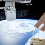 A mesmerizing view of Earth as seen from a space station with solar panels and satellite modules.