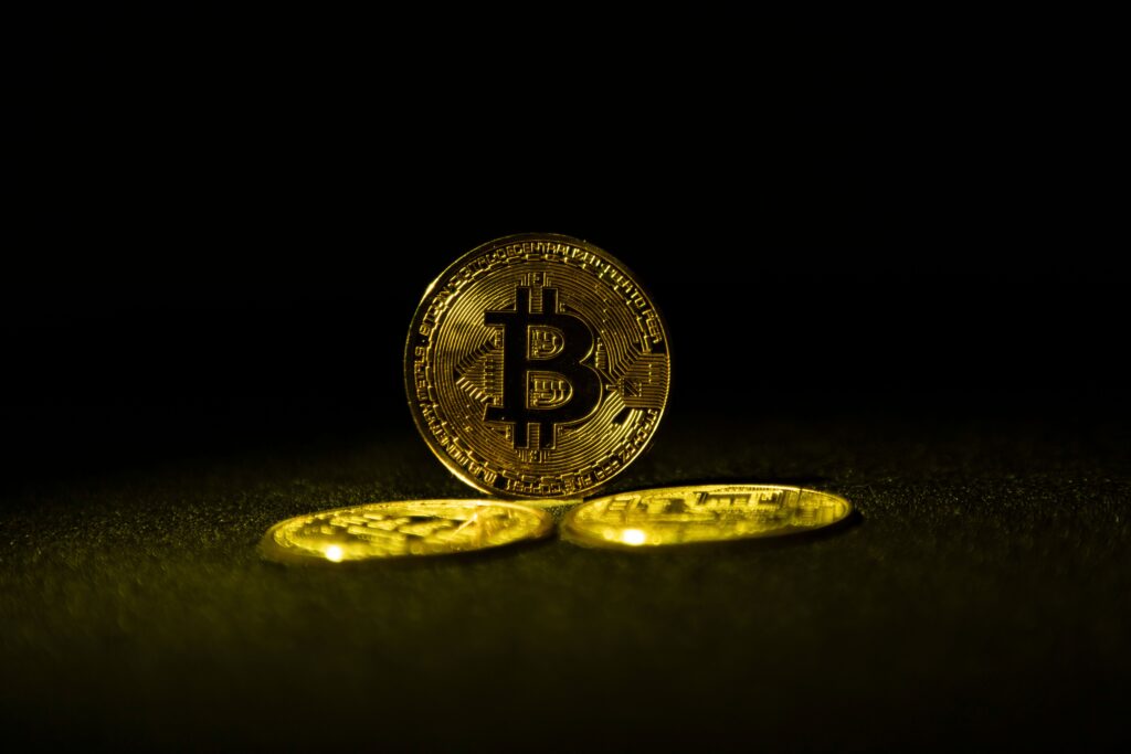 Golden Bitcoin coins symbolizing cryptocurrency wealth on a dark background.