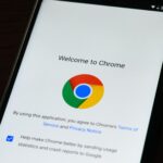 Close-up of smartphone displaying Google Chrome's welcome page and logo.