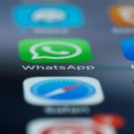 Detailed close-up of a smartphone's home screen displaying popular applications like WhatsApp.