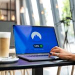 A person using a laptop with a VPN connection in a modern cafe setting, showcasing remote work and internet security.